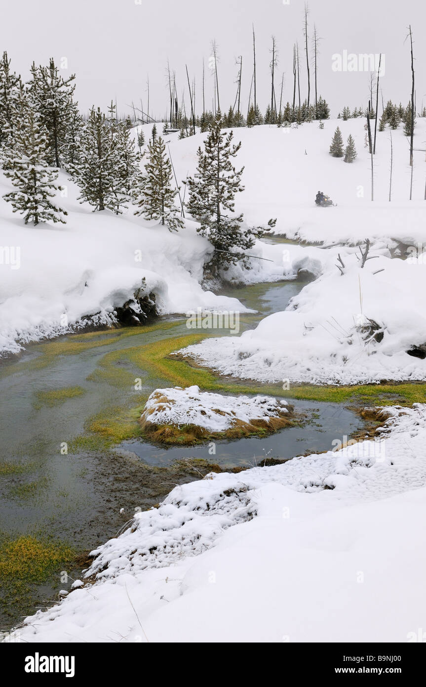 La obsidiana Creek hot springs geothermally climatizada en invierno con la motonieve Parque Nacional Yellowstone en Wyoming USA Foto de stock