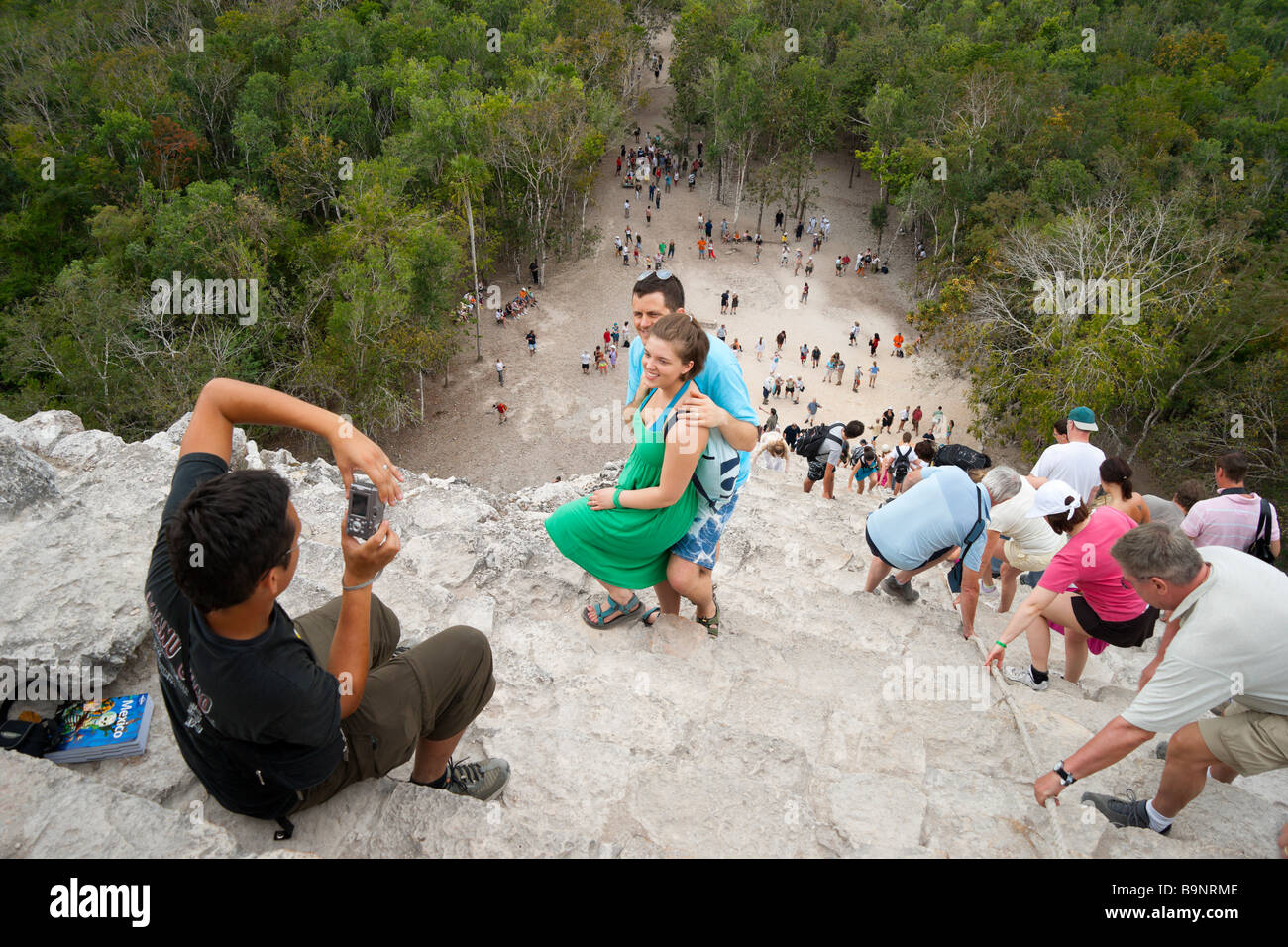 México - Yucatán Maya Coba ruinas históricas complejas, los visitantes tomando fotos en la parte superior de la ascensión - pirámide Nohoch Mul Foto de stock
