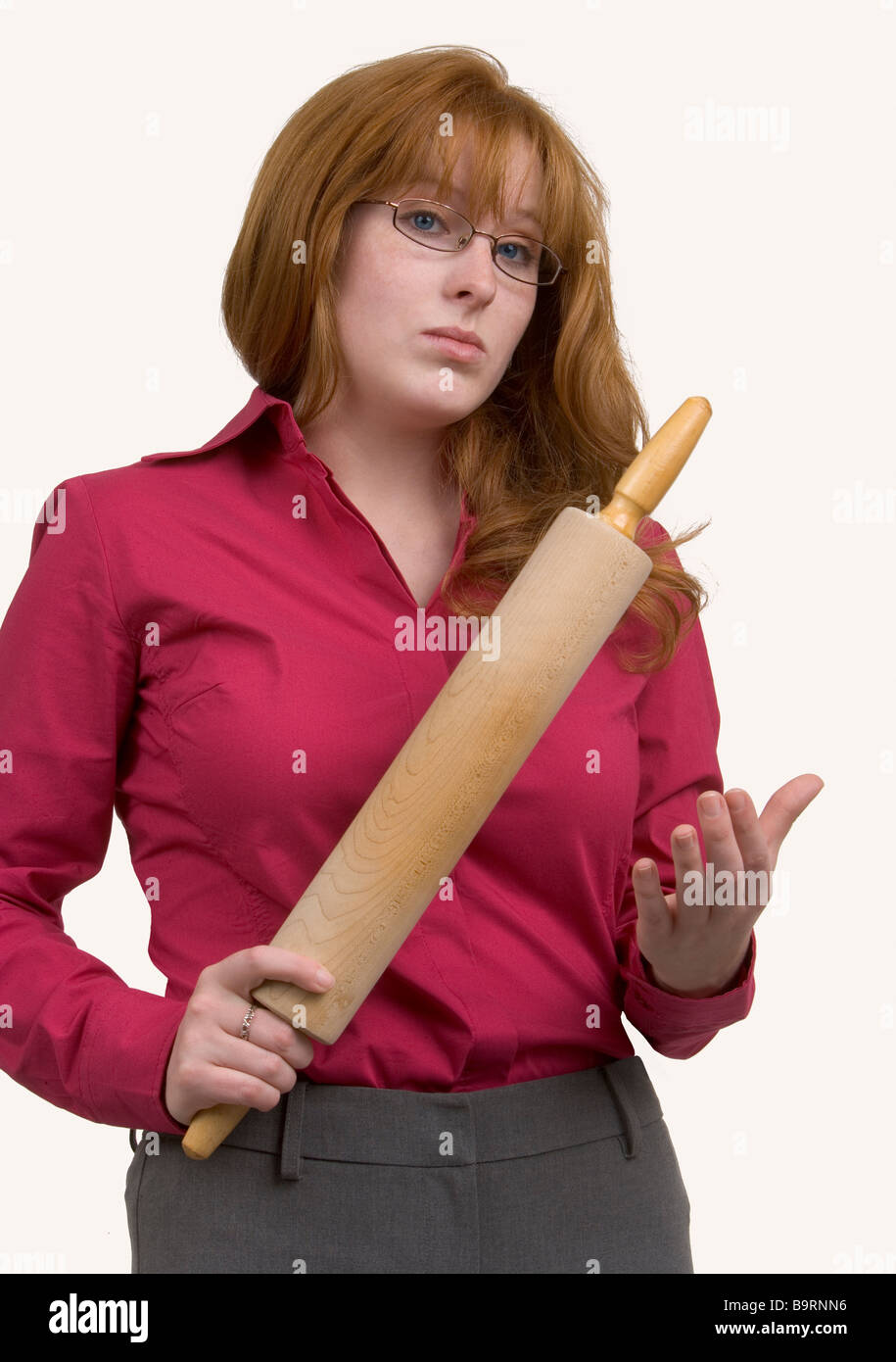 Una airada pelirroja mujer con un laminado de madera picados en una manera amenazante. Foto de stock