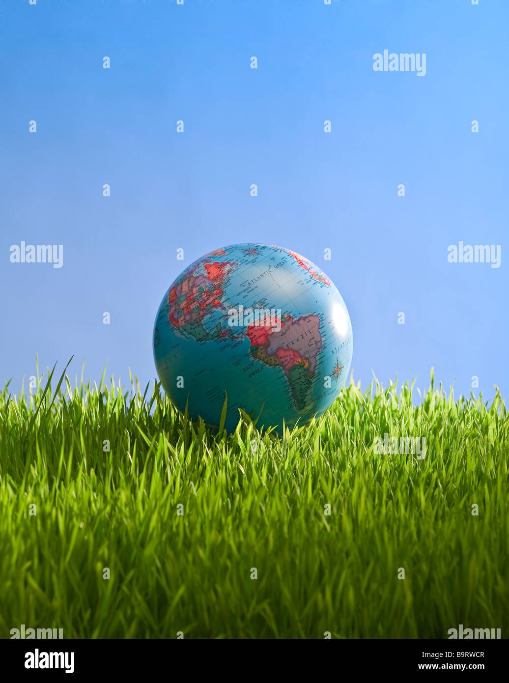 Globe en la hierba con el cielo Foto de stock