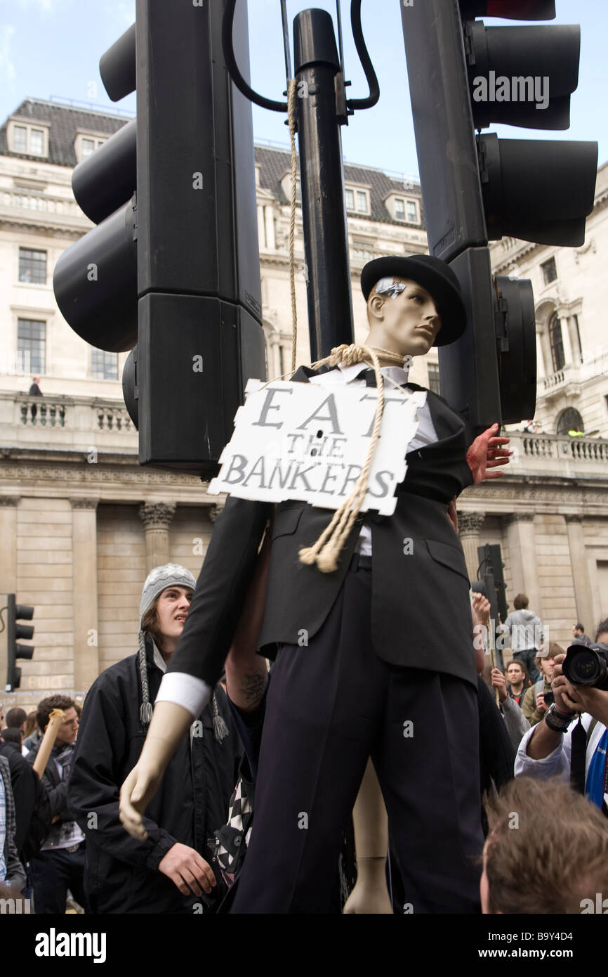 Los manifestantes anarquistas la realización de un simulacro de ahorcamiento de un maniquí vestido como un banquero durante protestas contra el capitalismo en la ciudad Foto de stock