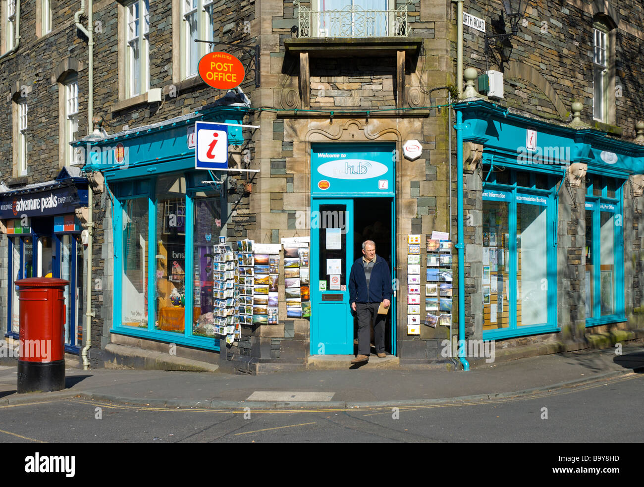 El hombre sale de la oficina de correos y el Centro de Información Turística de Ambleside, Lake District National Park, Cumbria, Inglaterra Foto de stock