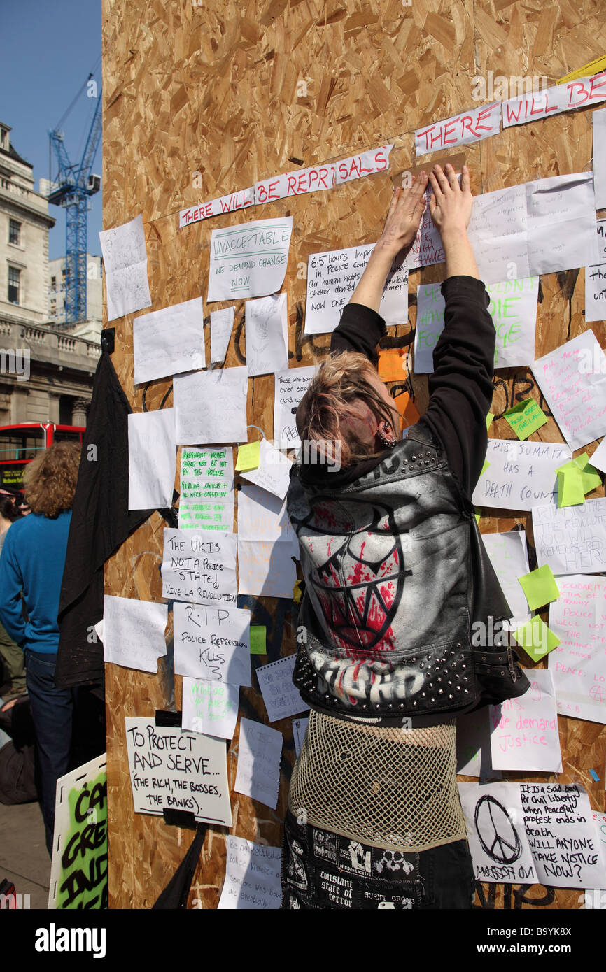Hombre publicar un mensaje de protesta en una placa fuera del Banco de Inglaterra en 2009, durante la cumbre del G20, Londres, Reino Unido. Foto de stock