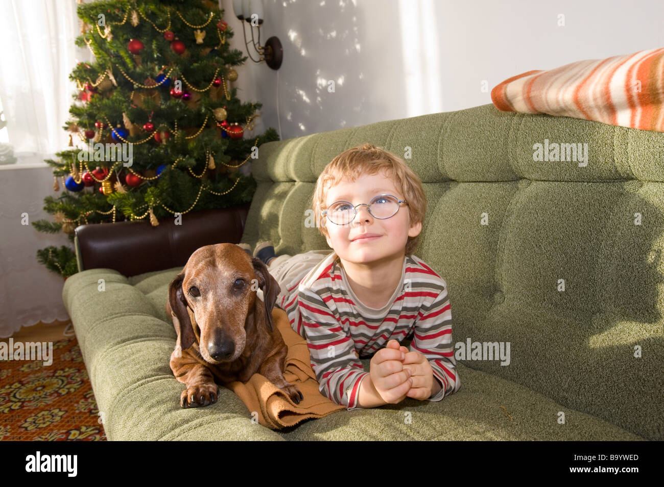 Niño de 3 años con un perro en el sofá Polonia Foto de stock