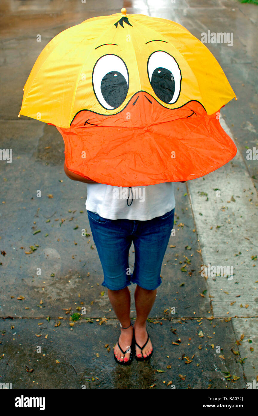 Hilarante shot de dama y Paraguas formado a la forma de la cabeza y de la  cara del pato parado en la lluvia Fotografía de stock - Alamy