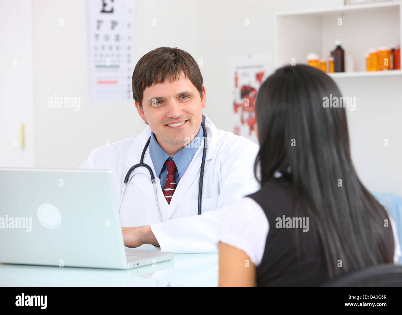 Doctor en consultoría de escritorio con paciente Foto de stock