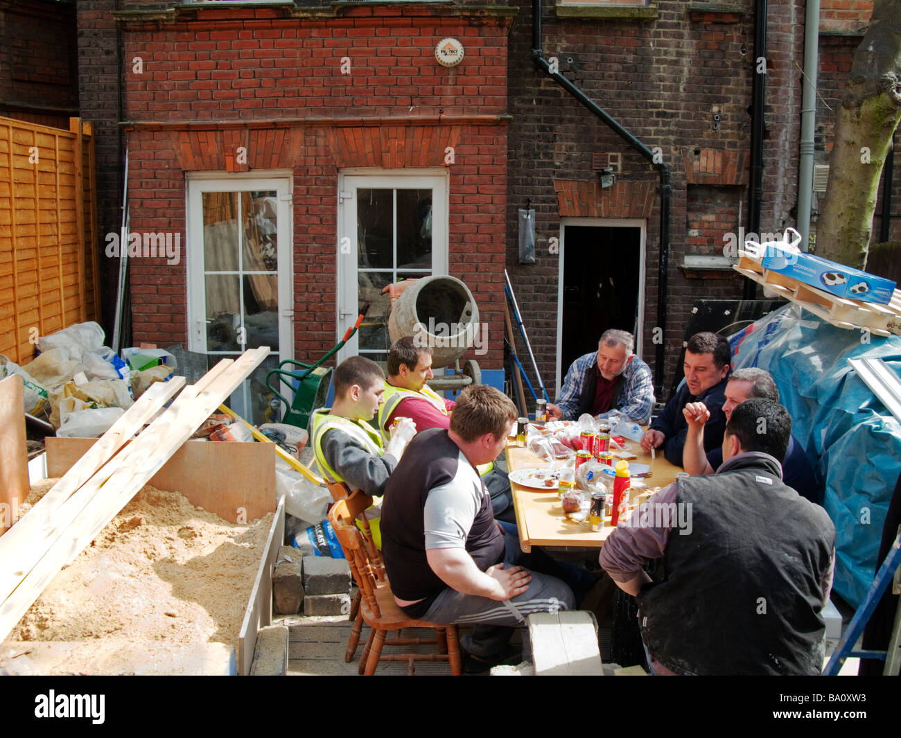 Los constructores de Europa oriental tomar un descanso para el almuerzo en el sitio de construcción de Londres, Inglaterra Foto de stock
