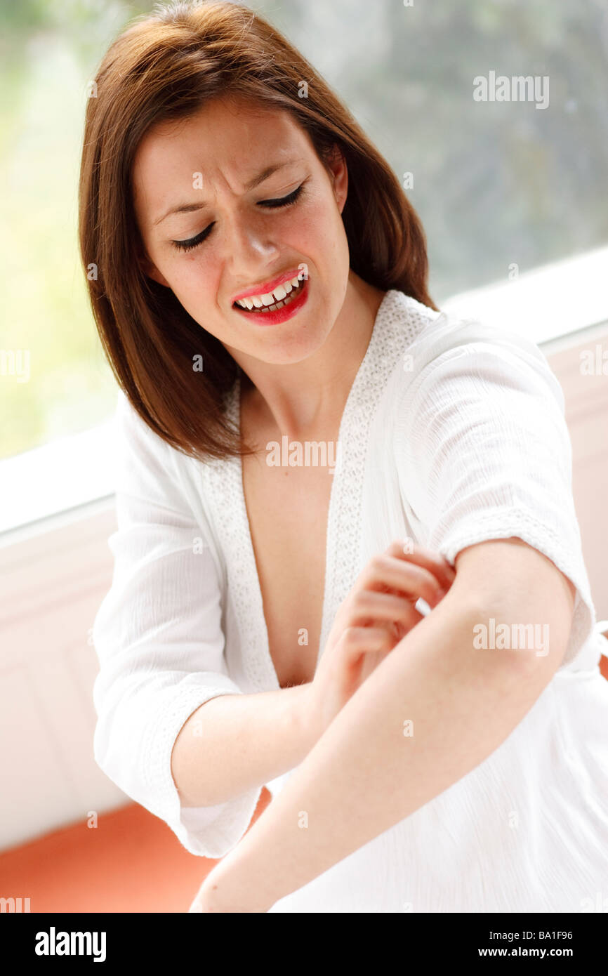 Mujer rascarse el brazo Foto de stock