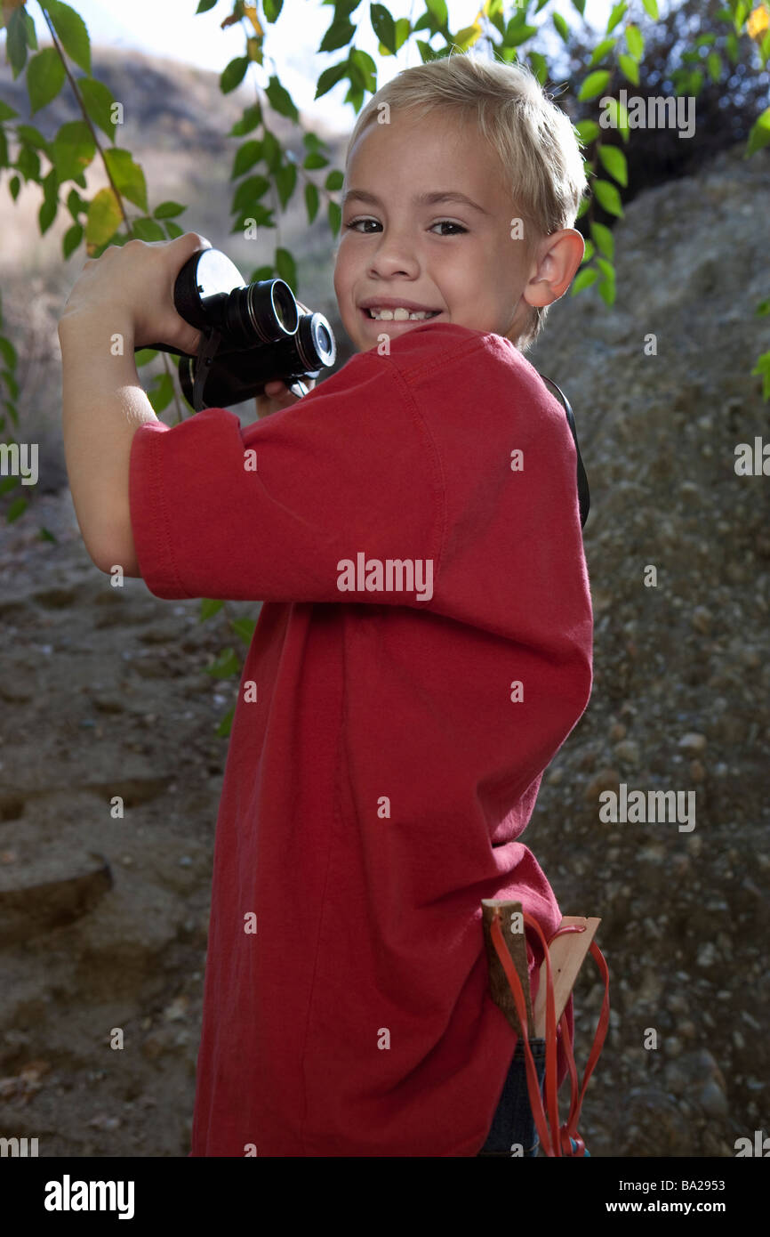 Boy (7-9) usando binoculares Foto de stock