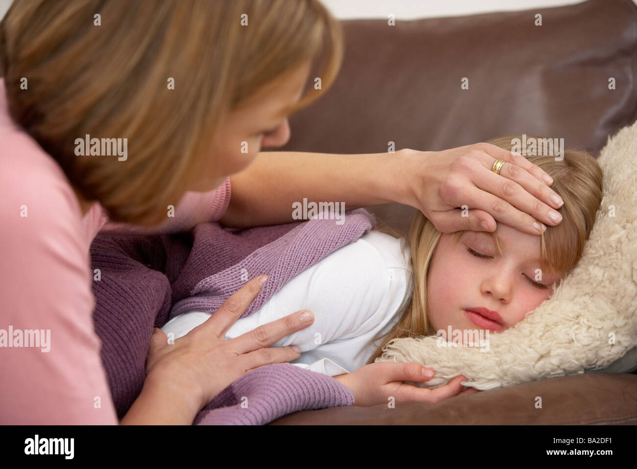 La madre toma temperatura de hija enferma Foto de stock