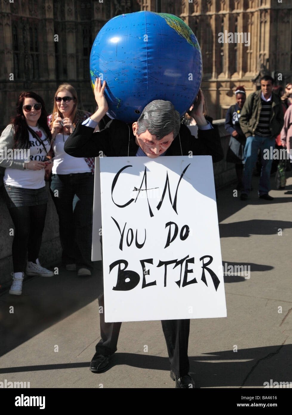 Efigie de Gordon Brown sujetando el mundo con un cartel: lo puedes hacer mejor fuera del Parlamento Westminster Londres England Reino Unido Foto de stock