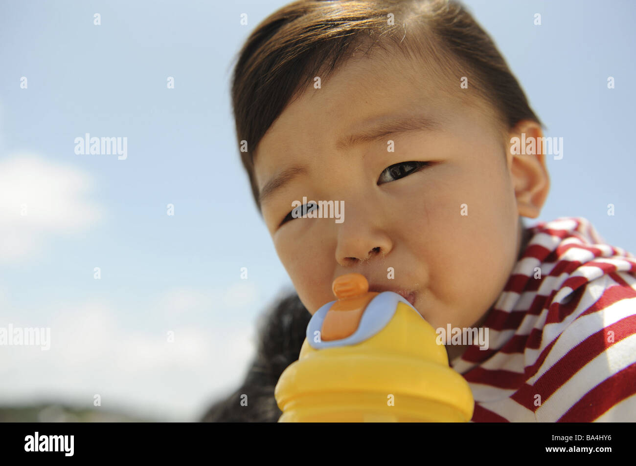 Niño bebiendo de un vaso de plástico Foto de stock