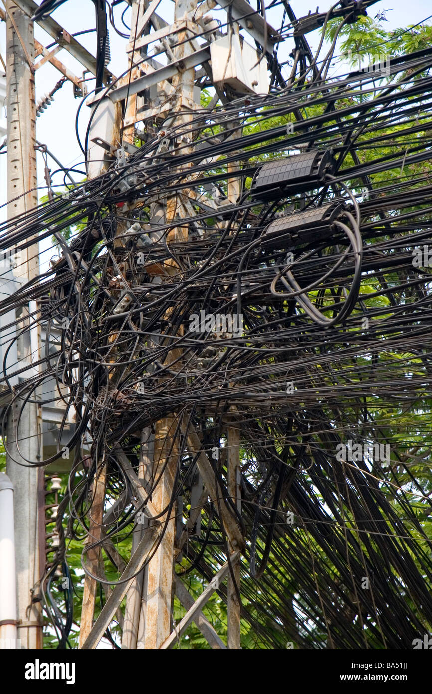 Una maraña de cables telefónicos en un poste del alumbrado público en la ciudad de Ho Chi Minh, Vietnam Foto de stock