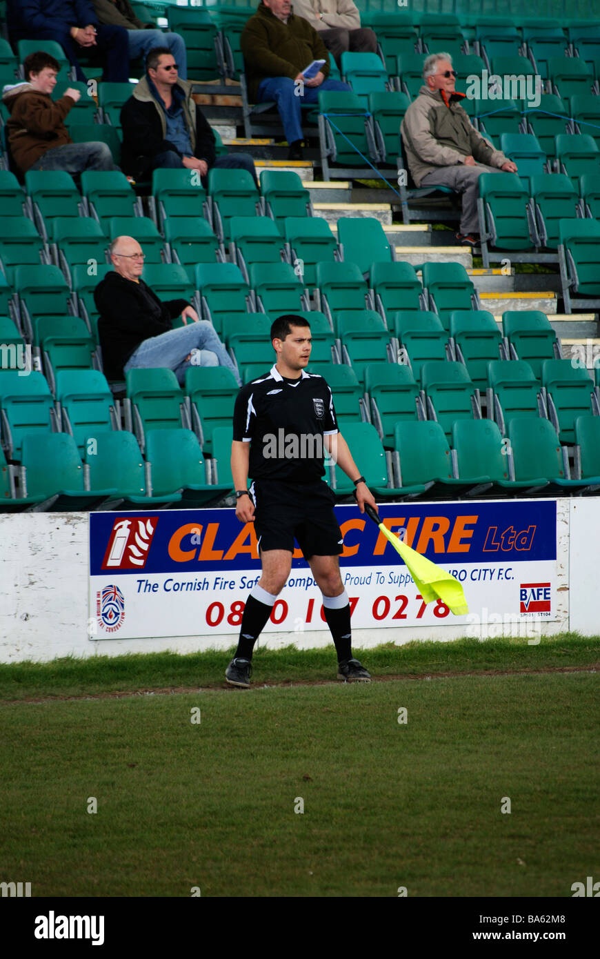 Un ayudante de árbitros ejecutando la línea en un partido de fútbol Foto de stock