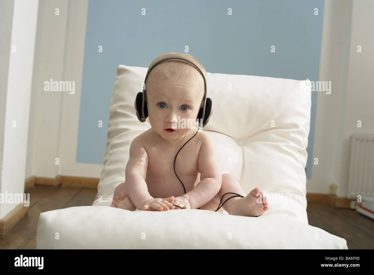 Sillas de bebé desnudo se sienta auriculares escucha música sonrisas series  personas niño niño 8 meses iPod MP3-Player Musikhören actividad Fotografía  de stock - Alamy