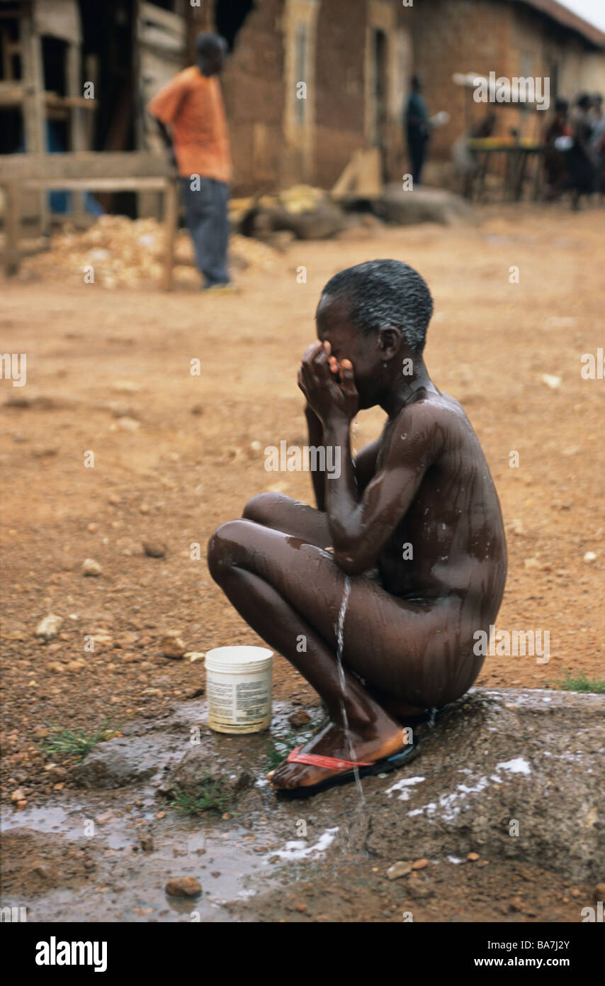 Pobre muchacha desnuda lavarse a sí misma en una concurrida calle Ghana un  humillante acontecimiento cotidiano que la gente ignore Fotografía de stock  - Alamy