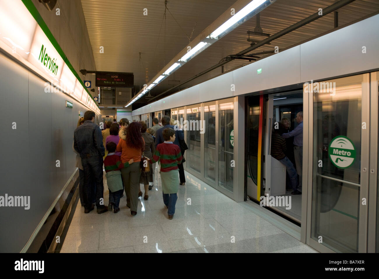 Los pasajeros que salen de un tubo de metro tren con barreras y puertas  abiertas detrás de ellos. La estación de Nervión, en Sevilla. España  Fotografía de stock - Alamy