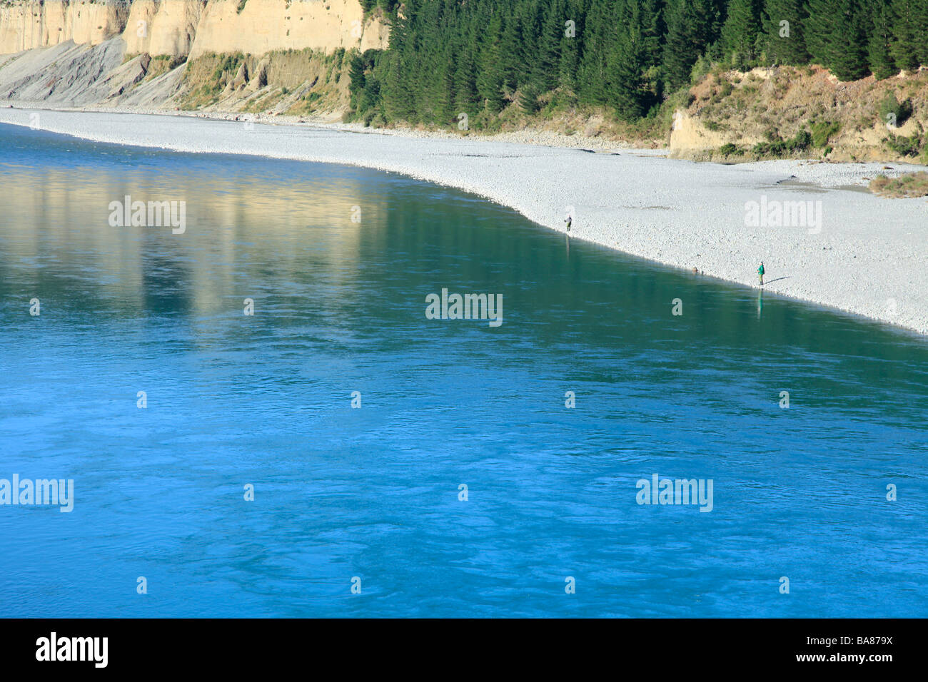 La pesca del salmón en el azul glacial agua fresca del río Rakaia, Canterbury, Isla del Sur, Nueva Zelanda Foto de stock