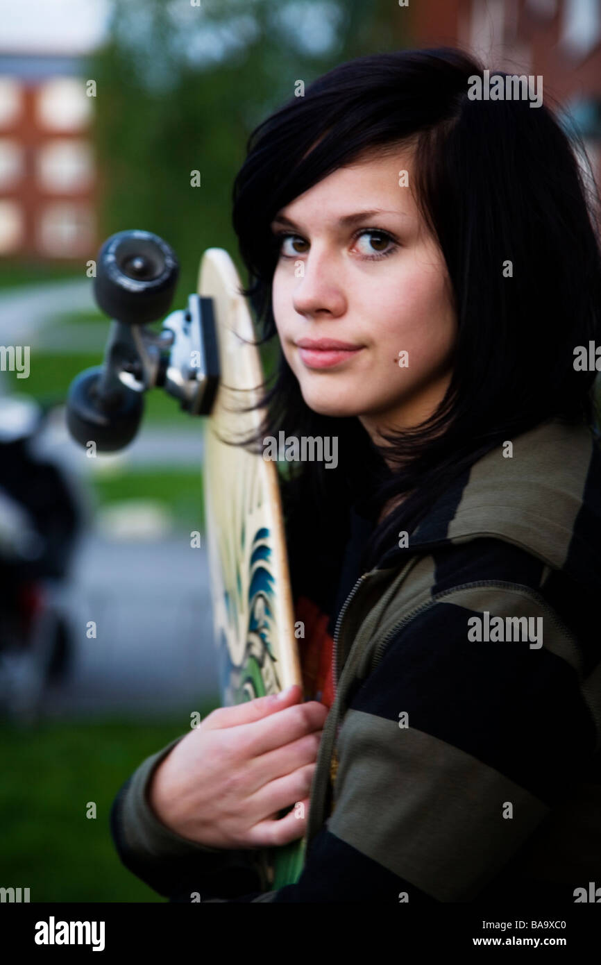 Una Chica sujetando un monopatín, Suecia. Foto de stock