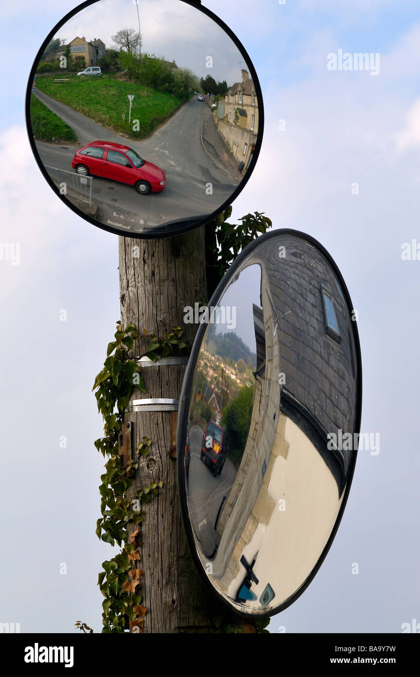 Seguridad vial dos espejos montados en la pole por cruce rural en Cotswolds para mejorar la visibilidad Foto de stock