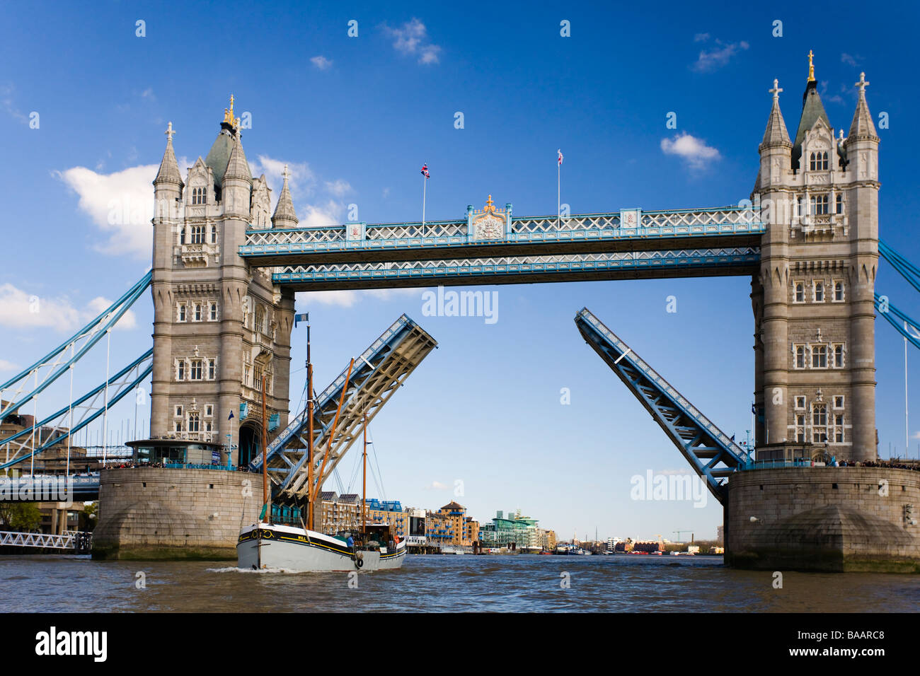 Londres England Reino Unido Tower Bridge se abren con una barcaza del Támesis atravesando Foto de stock