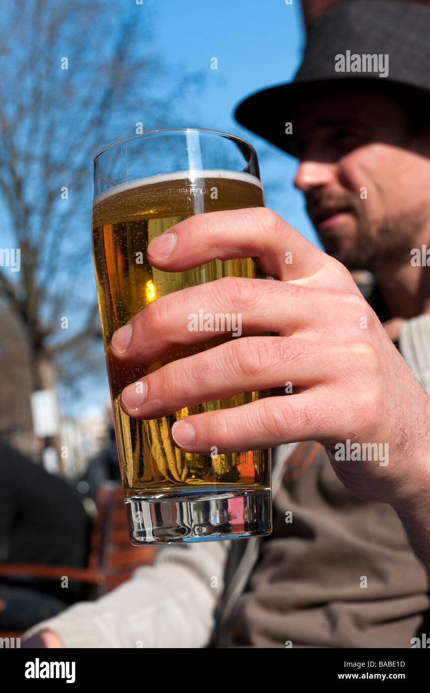 Hombre bebiendo una pinta de cerveza fuera pub UK Foto de stock