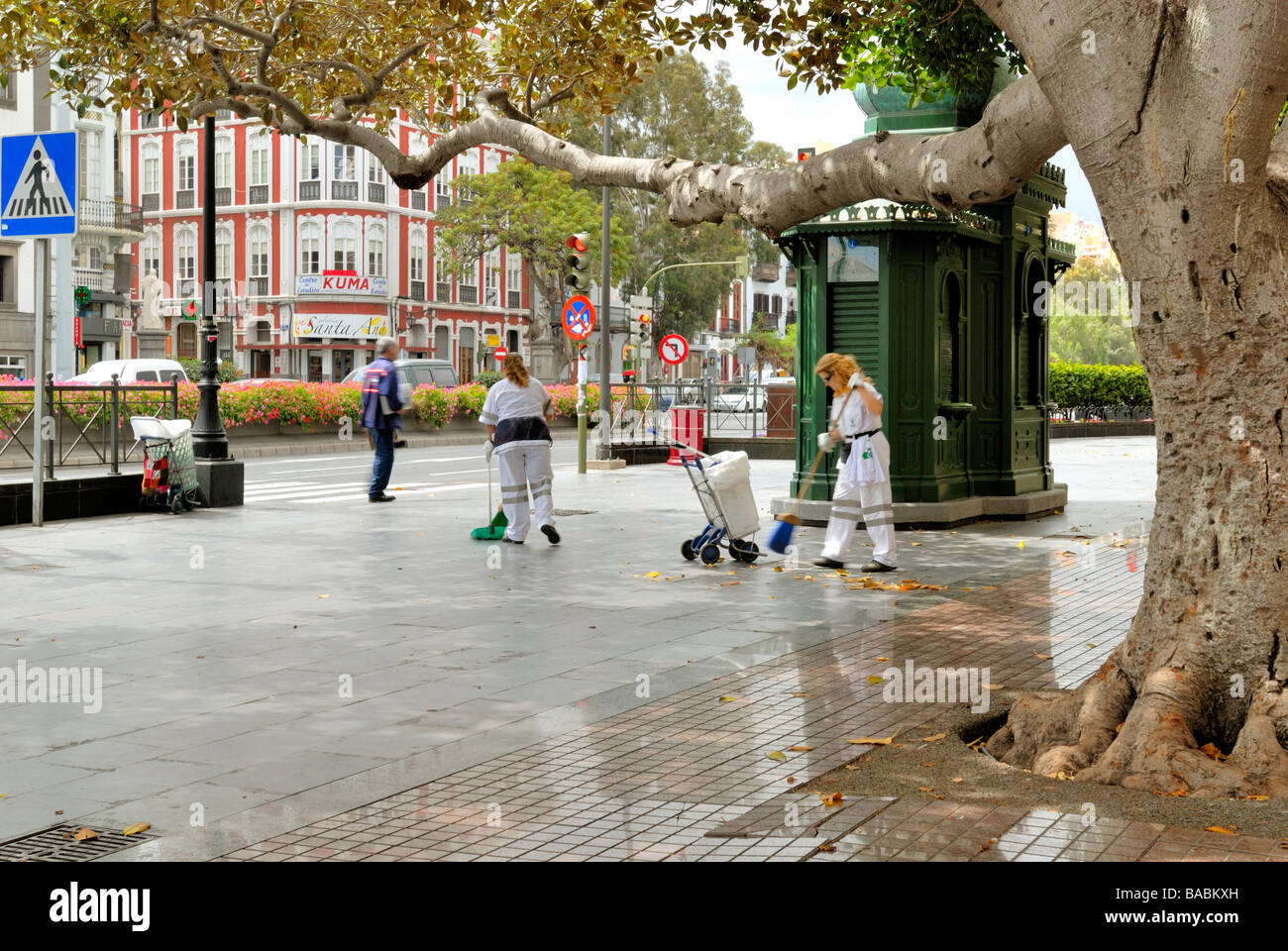 Las mujeres barriendo la calle en la Plaza Hurtado de Mendoza, también conocida como la Plaza de las Ranas, en el antiguo y elegante distrito de Tri Foto de stock
