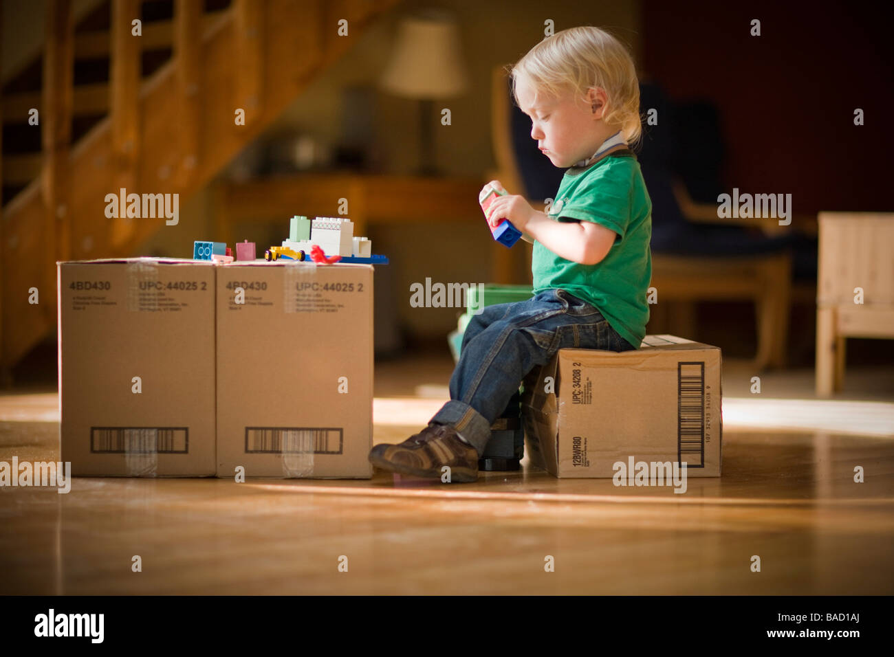 Niño jugando con juguetes en cajas de cartón Foto de stock