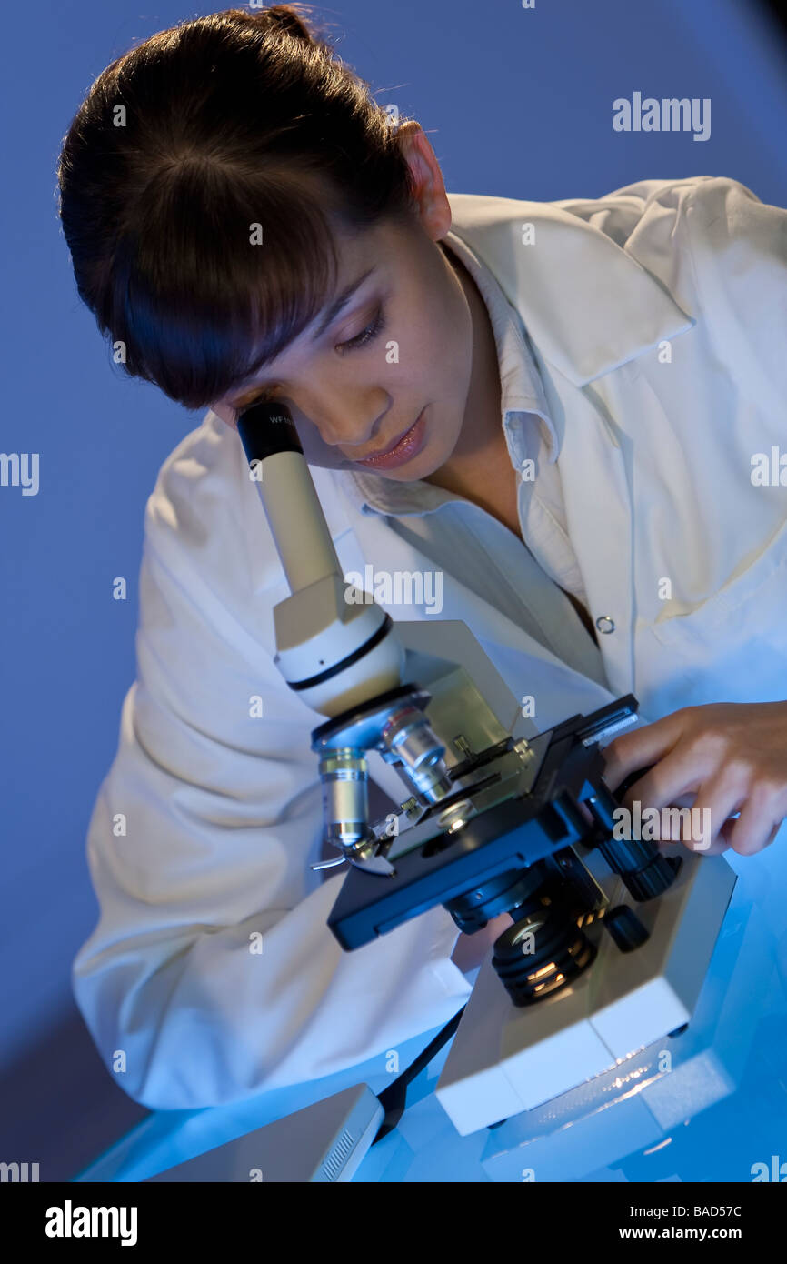 Una hermosa hembra investigador médico o científico utilizando su microscopio Foto de stock