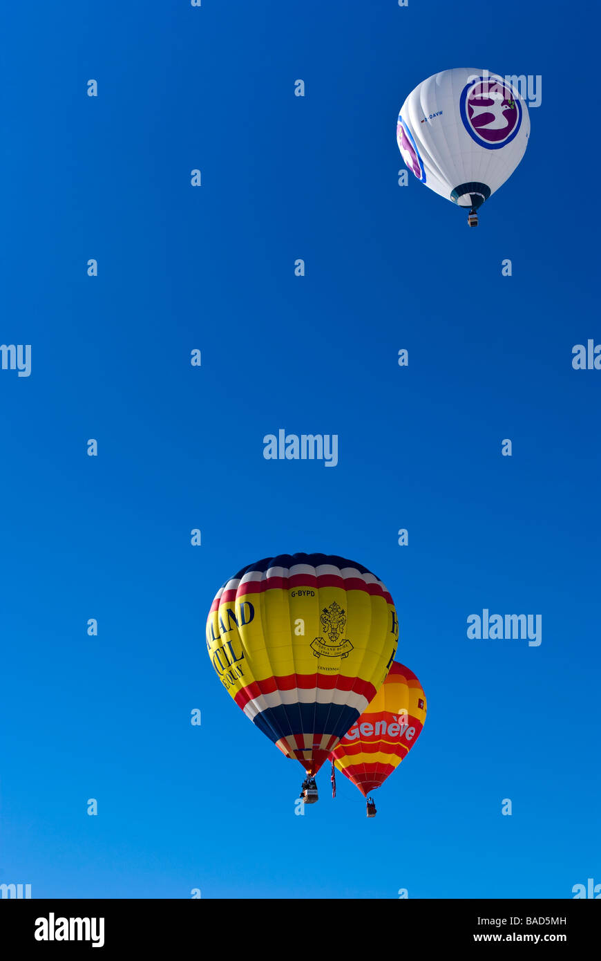 Los globos de aire caliente subiendo hacia el cielo azul claro en el 2009 Chateau d'Oex International Balloon Festival / carreras. Foto de stock