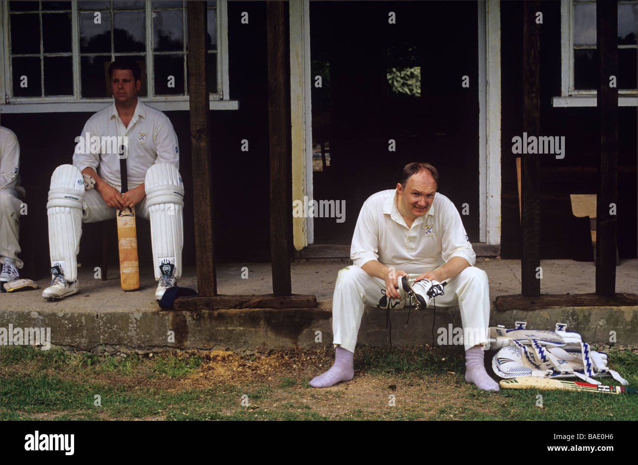 Bateadores esperando sus entradas durante un partido de cricket de aldea en Kent Foto de stock