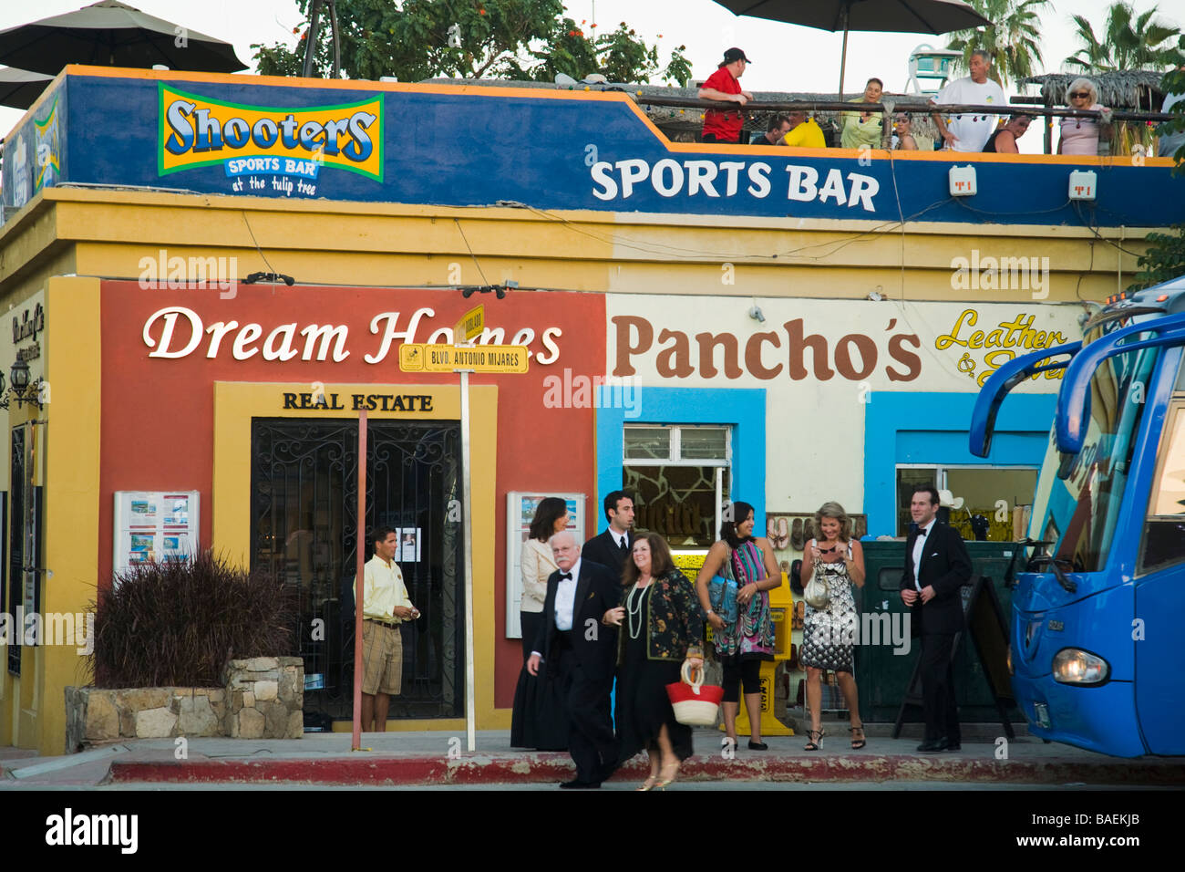 MEXICO San Jose del Cabo los invitados a una boda en ropa formal caminar pasado sports bar y tiendas en la ciudad de México Foto de stock