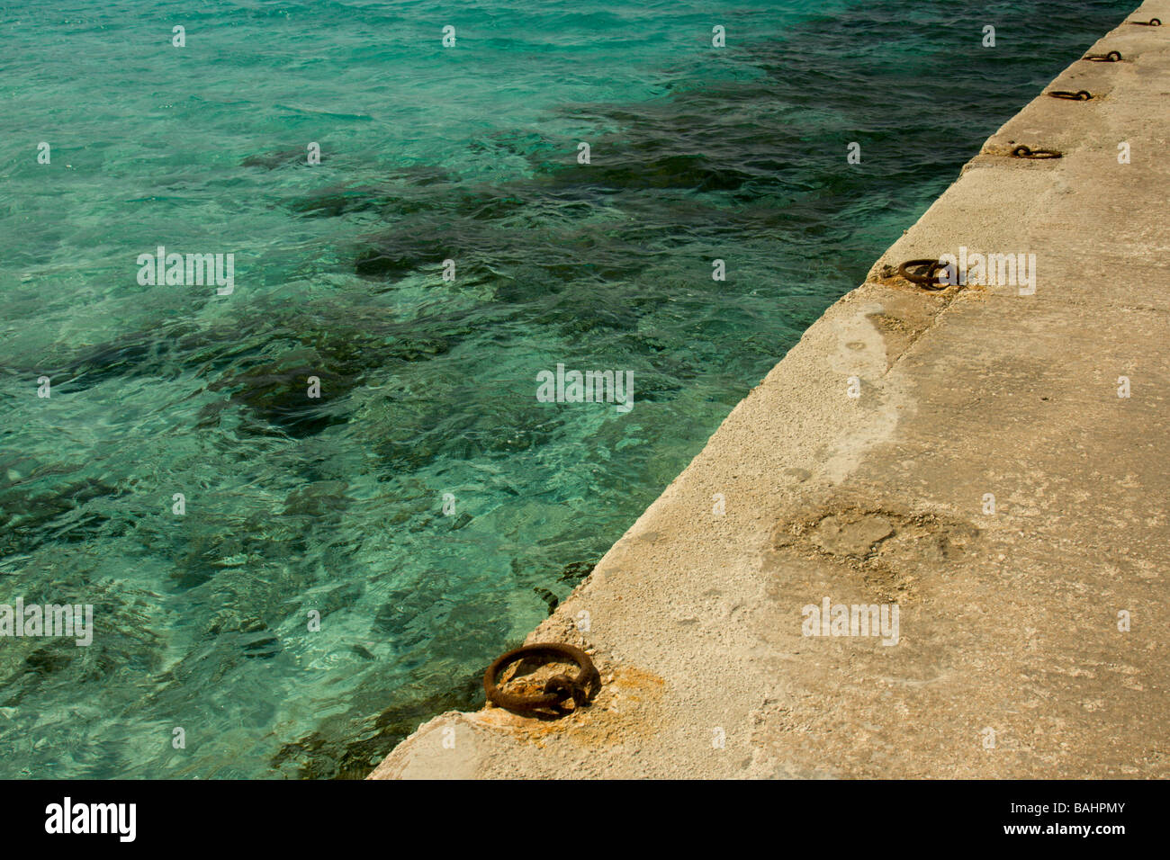 Cristalinas aguas azul celeste, en el principal punto de atraque para embarcaciones en la Laguna Azul en la isla de Comino Malta Foto de stock