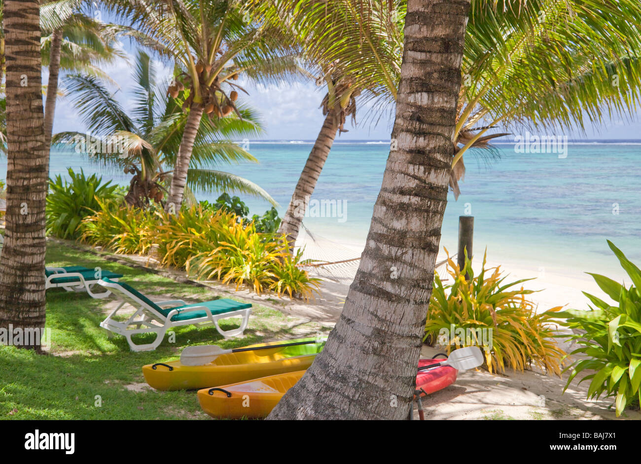 Playa tropical con palmeras, reposeras y kayaks de mar - Rarotonga, Islas Cook, Polinesia Foto de stock