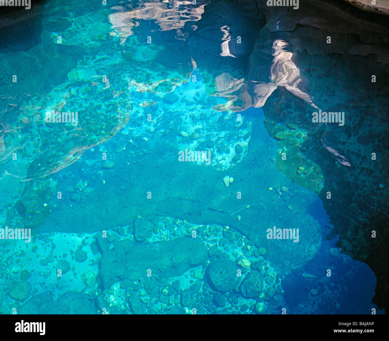 Surrealista reflexiones sobre la superficie del agua de un color turquesa waterpool de Wadi Bani khalid Foto de stock