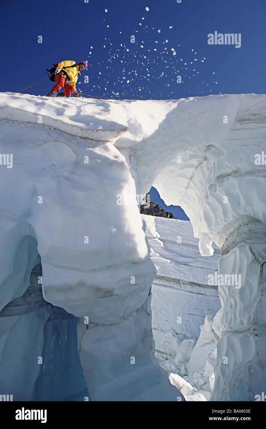 Escalador cruzar puente de nieve sobre el glaciar coleman Foto de stock