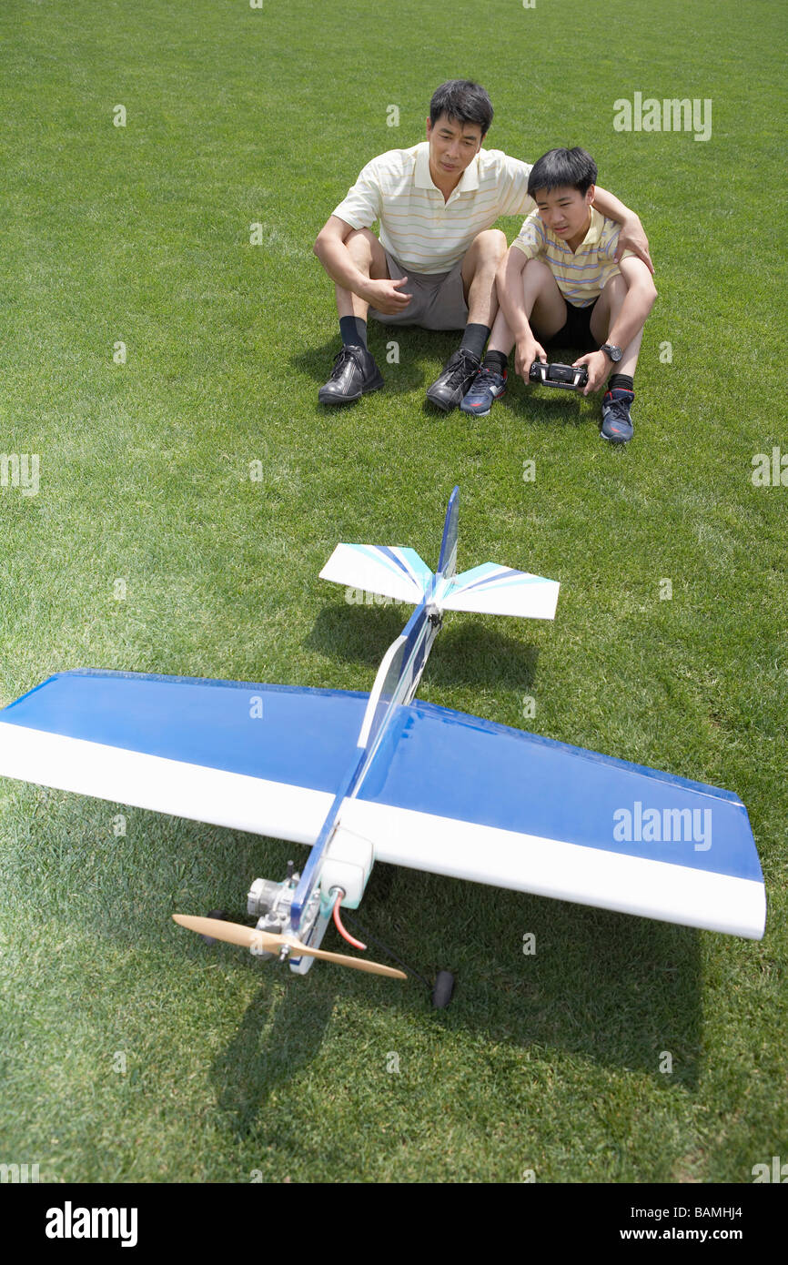 Padre e hijo jugando con modelo de avión Foto de stock