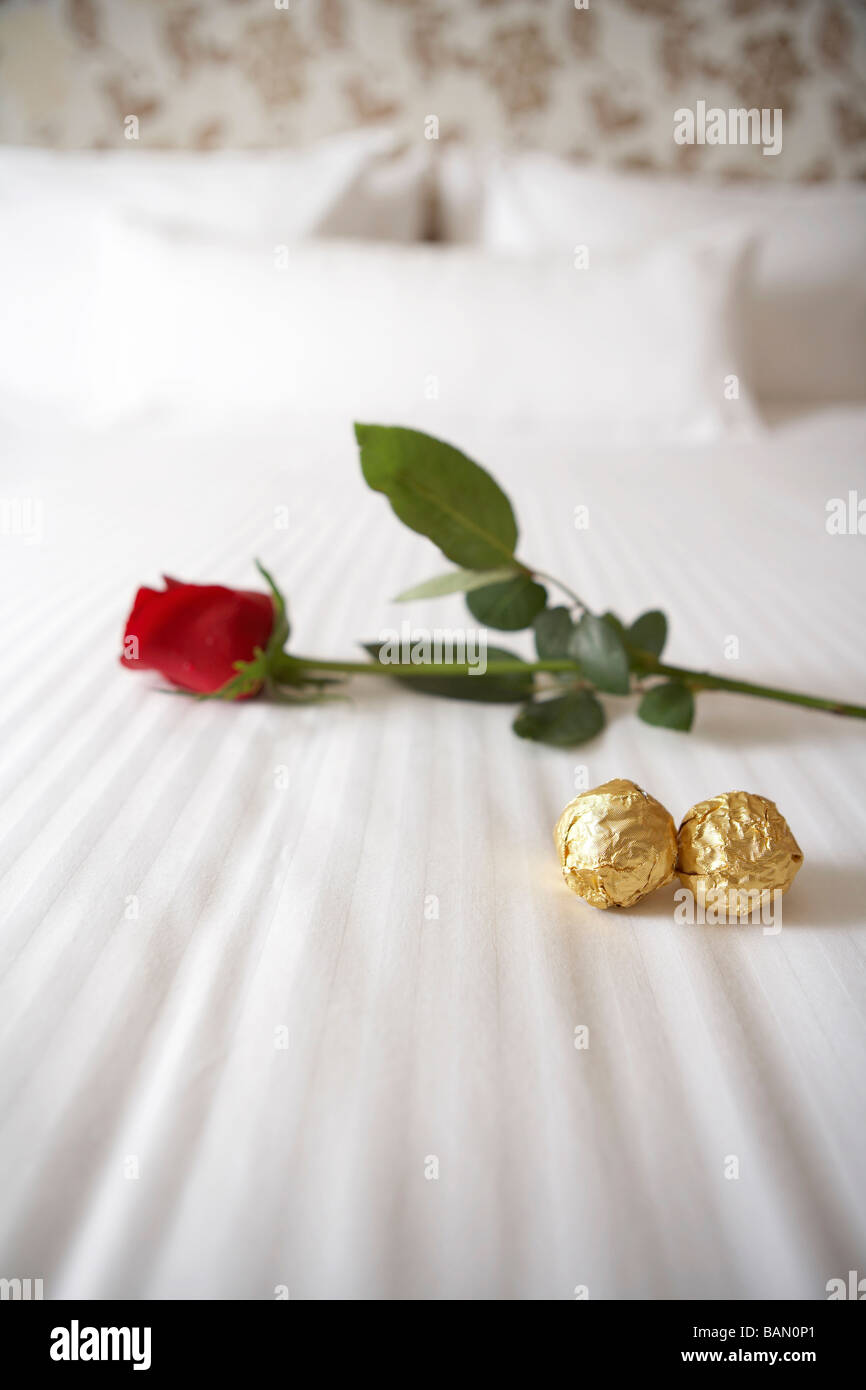 Rose y chocolates en una cama blanca Fotografía de stock - Alamy