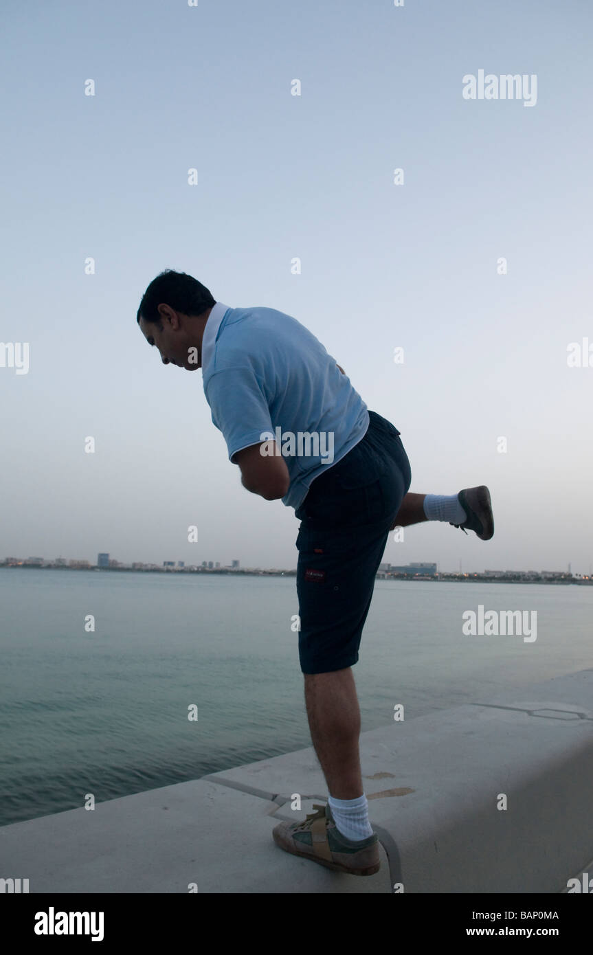 Señor indiano ejercer sobre el malecón en Doha Foto de stock