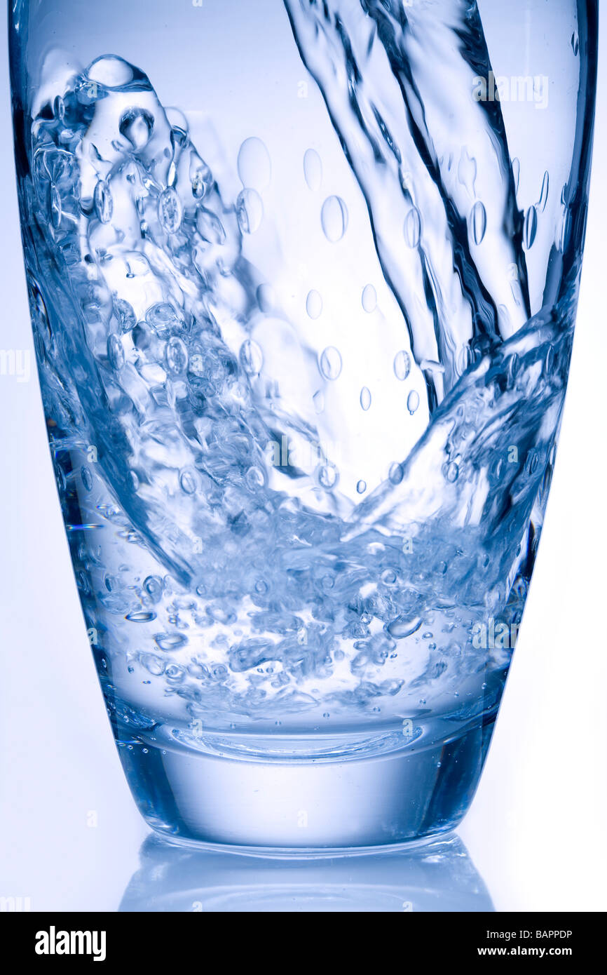 Vaso de agua mineral vertiendo Foto de stock