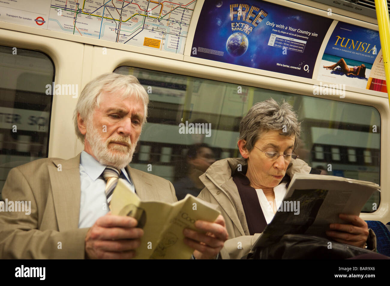Pareja leyendo, Metro de Londres, Londres, Inglaterra Foto de stock