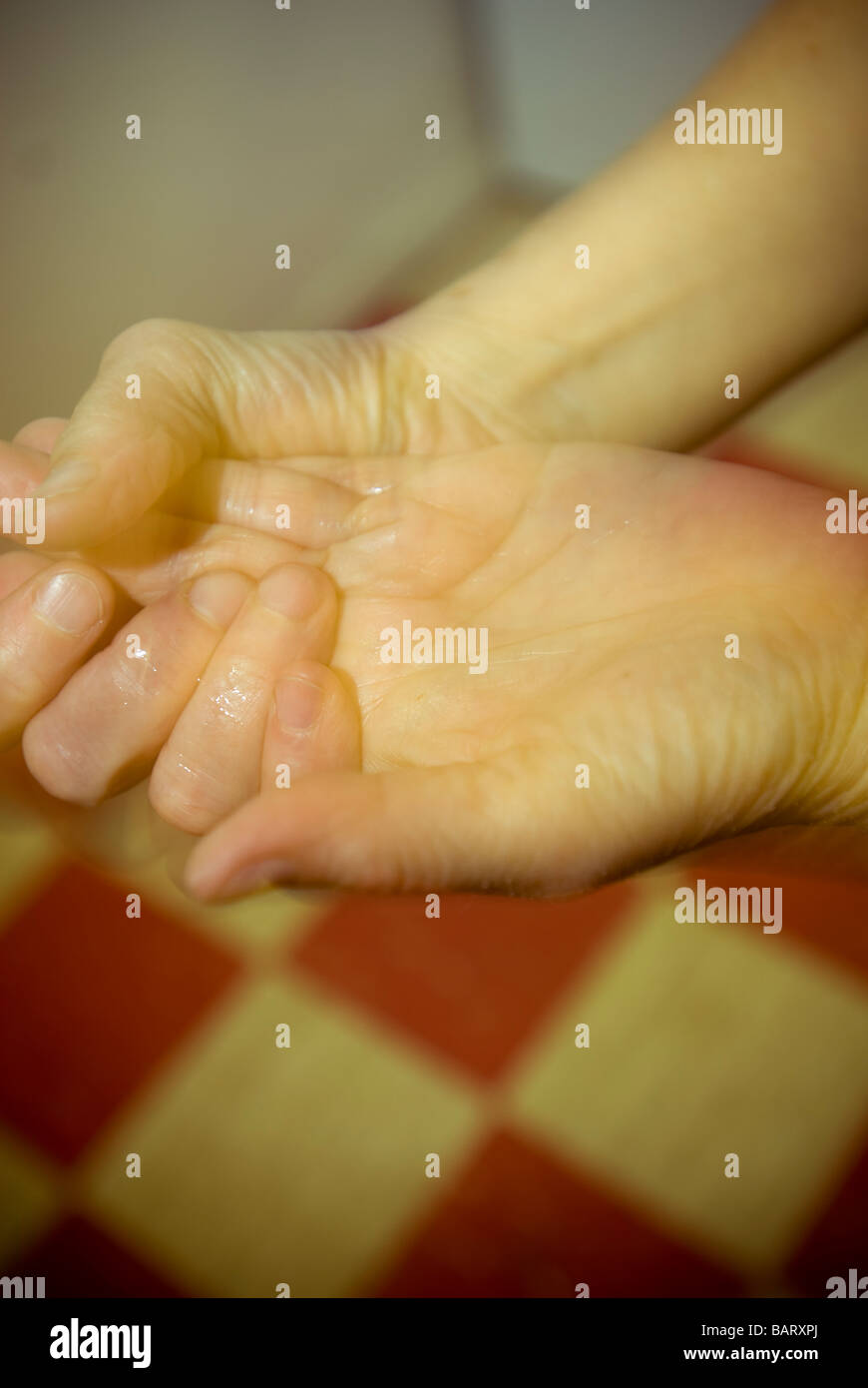 Una mujer lava sus manos con gel antiséptico y limpieza de manos Foto de stock