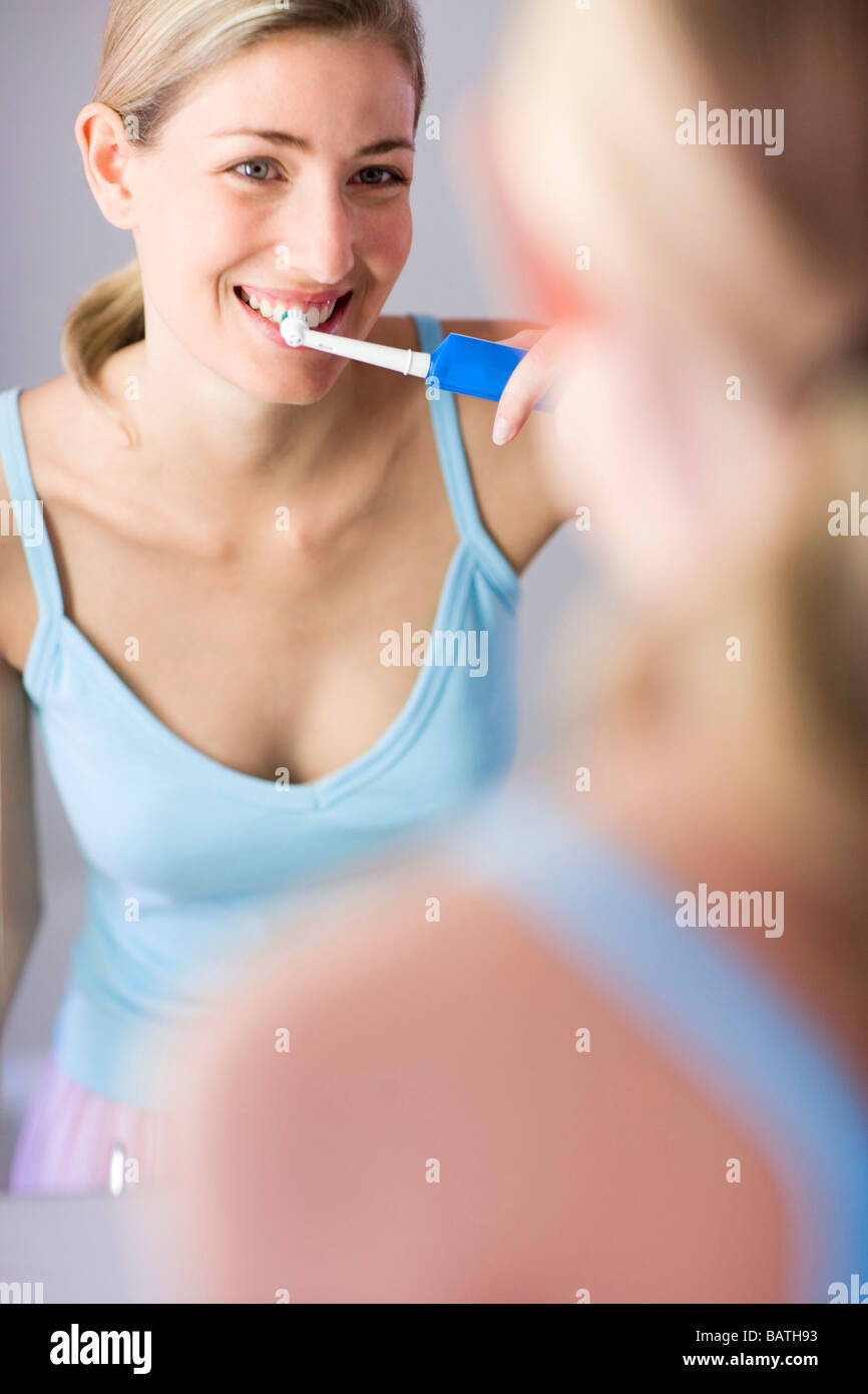 Cepillo dental eléctrico. Mujer el cepillado de los dientes con un cepillo dental eléctrico. Foto de stock