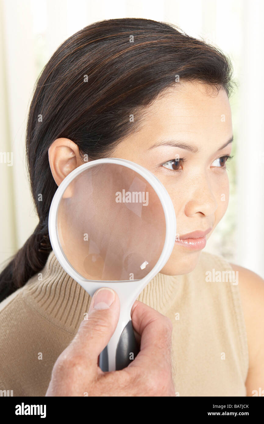 Examen dermatológico. El dermatólogo utilizando una lupa para examinar la  piel del paciente Fotografía de stock - Alamy