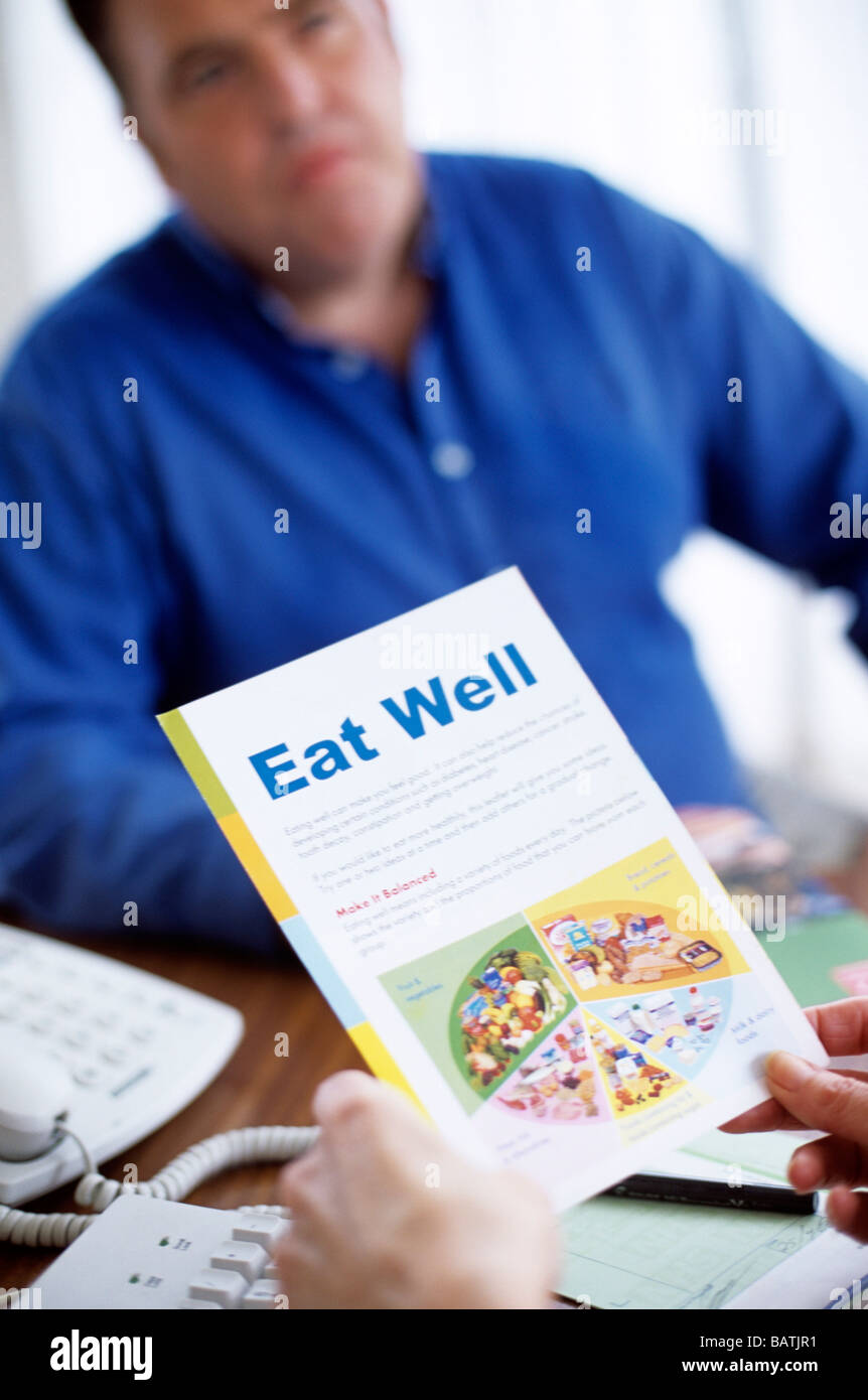 Asesoramiento nutricional. Nutricionista asesorando a un hombre obeso sobre cómo comer una dieta más equilibrada. Foto de stock