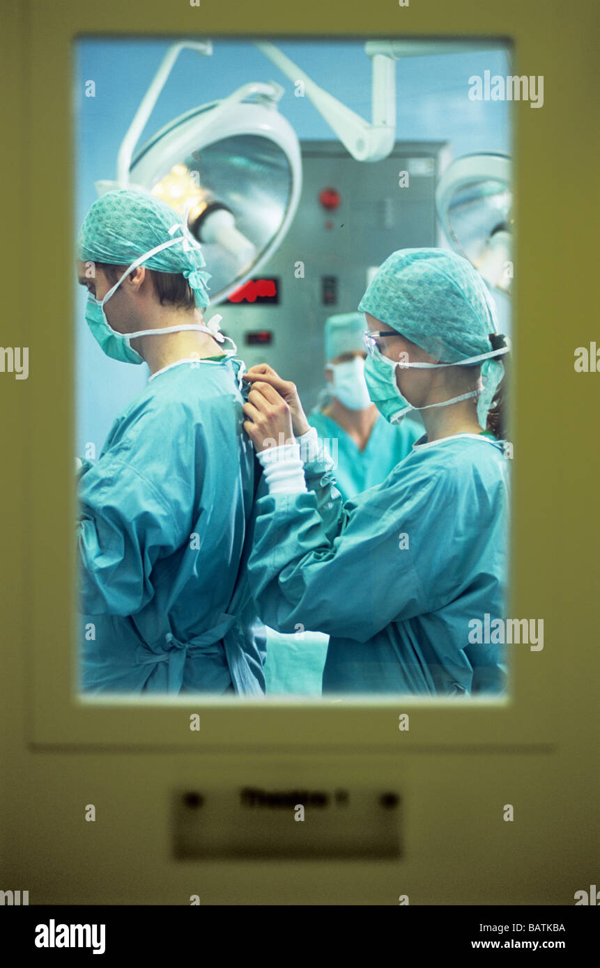 Preparación para la cirugí instrumentista ayudando a un cirujano para  vestir. Esta técnica evita la contaminación de las manos del cirujano  Fotografía de stock - Alamy