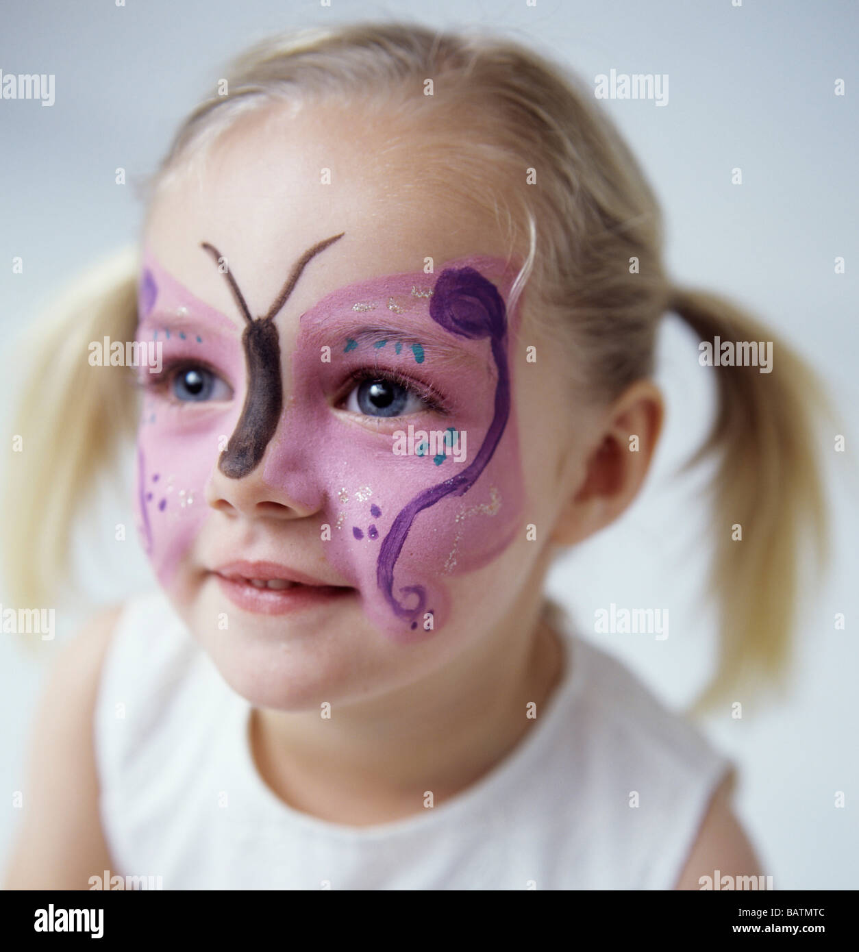 Pintura de cara. Niña de 3 años de edad que ha tenido su cara pintada con  un patrón de mariposas Fotografía de stock - Alamy