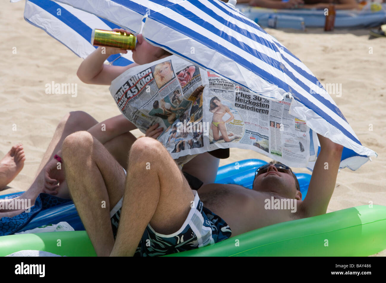 Los turistas alemanes bebiendo cerveza y leyendo Bild Zeitung, El Arenal, Playa de Palma, Mallorca, Islas Baleares, España Foto de stock
