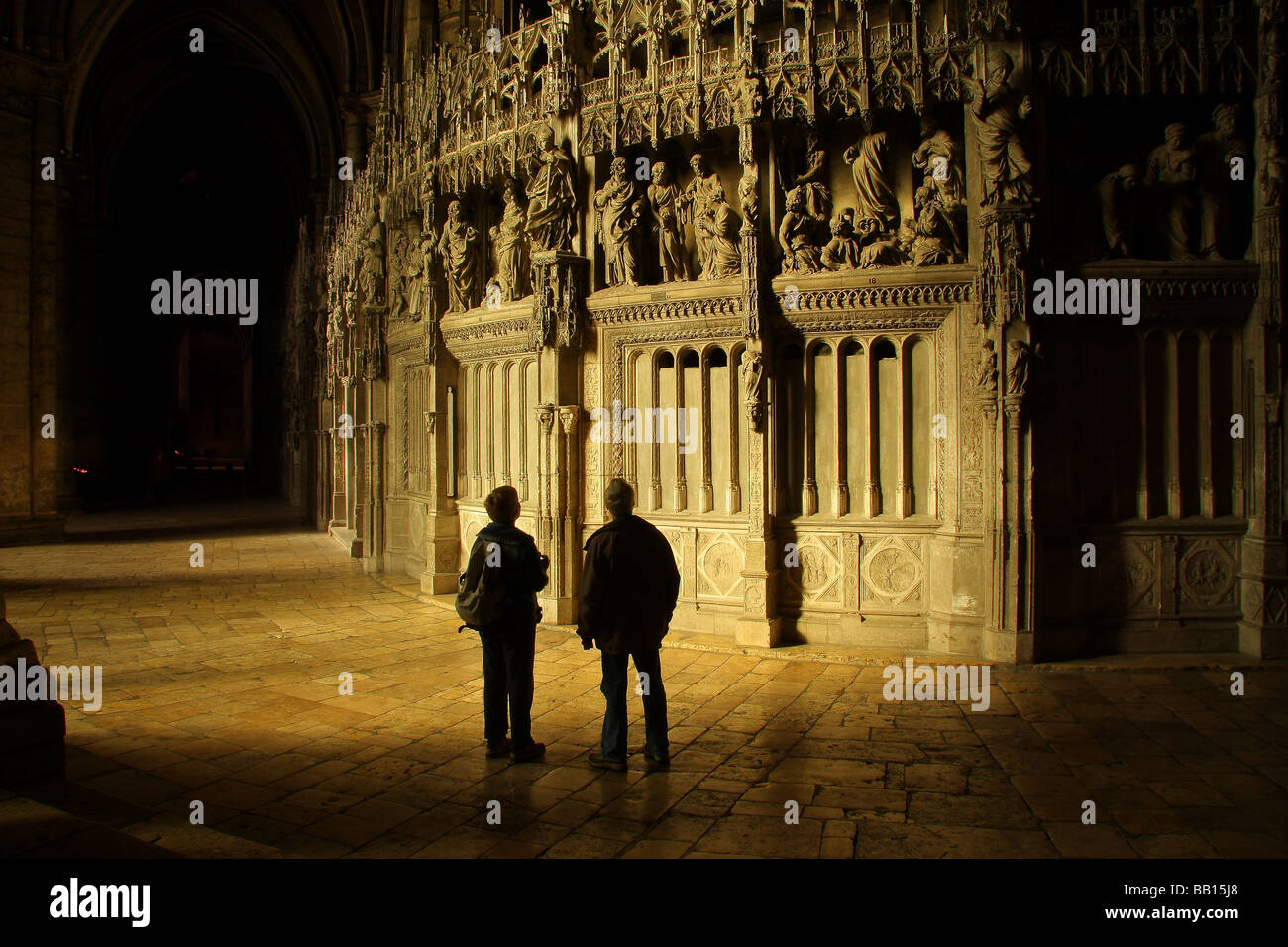 Dos visitantes mirando las tallas en la catedral de Chartres. Francia. Foto de stock