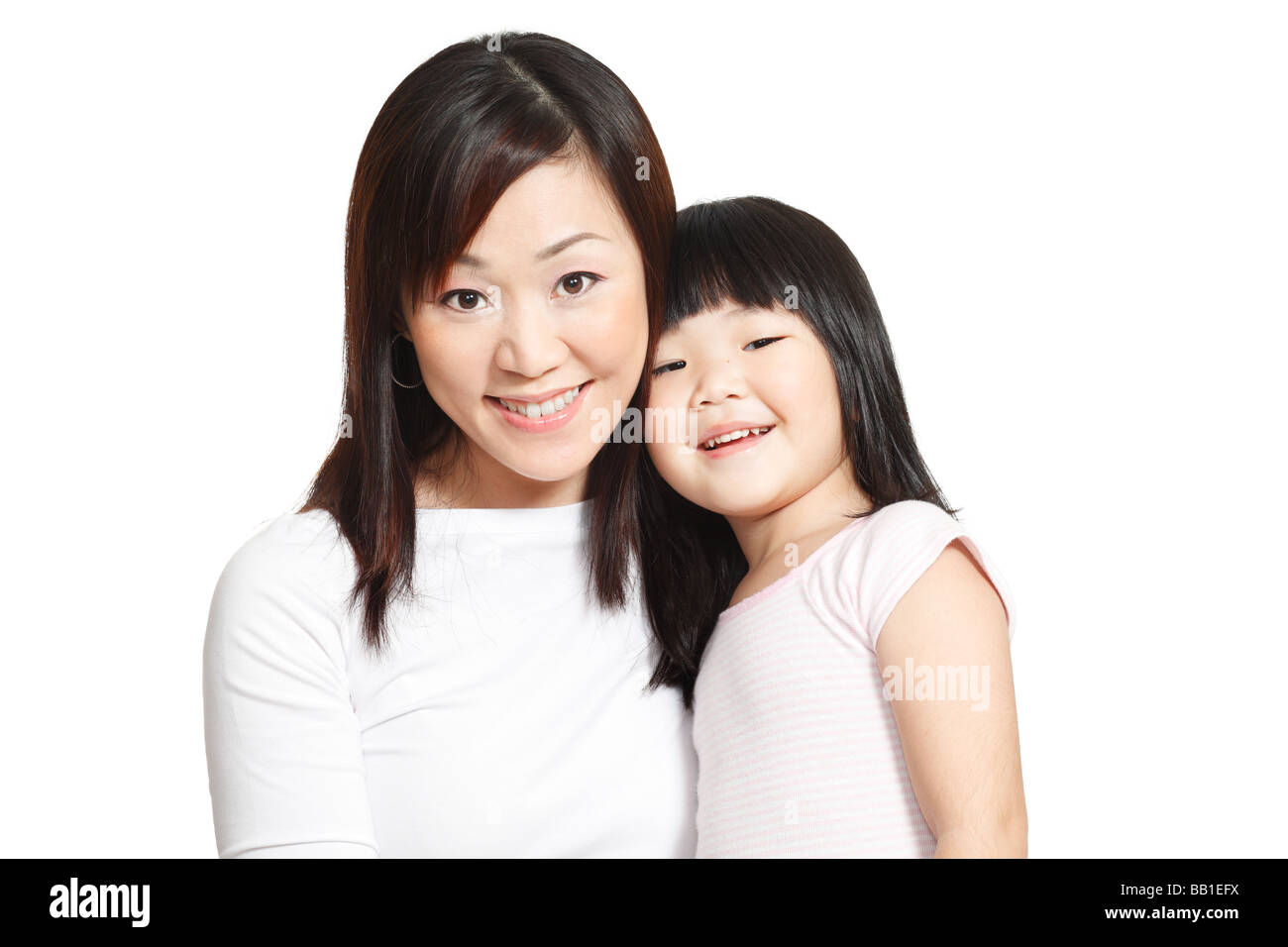 Feliz foto de niña china con su joven madre aislados en blanco Foto de stock
